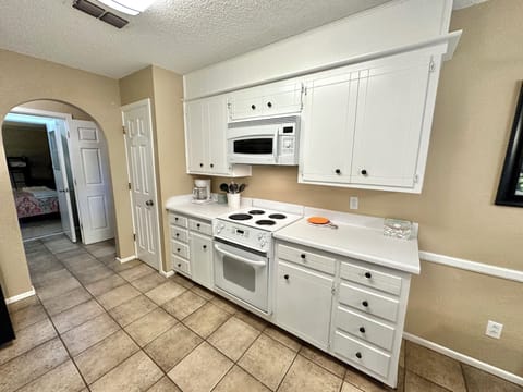 Pantry, coffee pot, electric stove and microwave.
