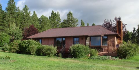 Historic timber (squared log) home in the mountain valley with stream and ponds.