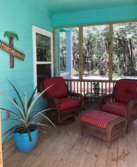 The screened porch has a lovely view of the oak forest across the street.