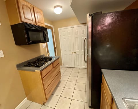 View of lower kithchen area showing cook top, microwave, side by side fridge/frz