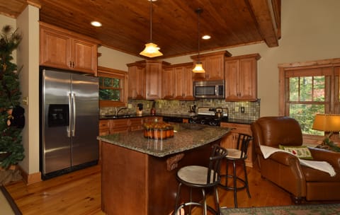 Spacious well-stocked kitchen with island and barstools