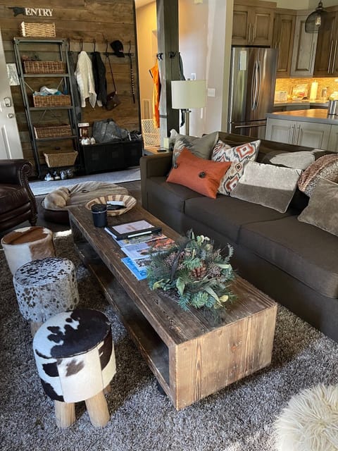 Updated family room photo showing addition of 3 cowhide stools at fireplace.