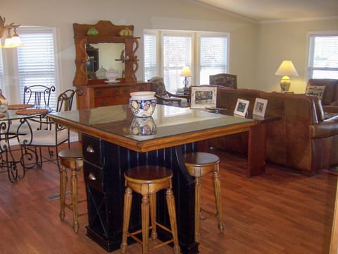 Large open living area with kitchen, island, dinette, and living room; all with expansive views of the lake.