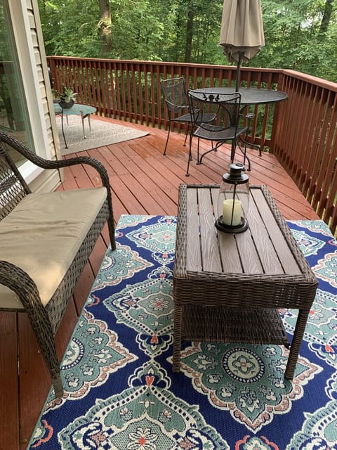 Other side of deck has dining table with umbrella, and another seating area
