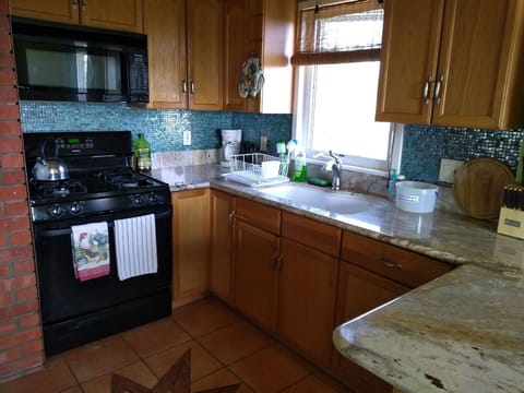 Kitchen with gas stove, microwave, fridge and toaster oven.
