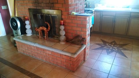 Living room fireplace and artful tiling design in kitchen floor.
