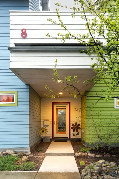Glass doors with the blinds drawn.  Front deck shelter.  Green back yard. 