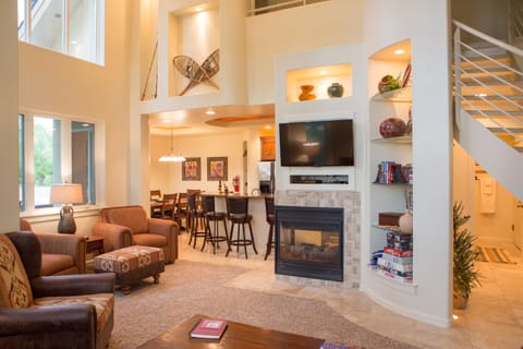 Living room with fireplace and games with four accent chairs and leather couch