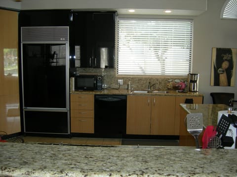 The kitchen area includes a bar height counter with chairs