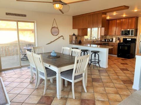 Kitchen and dinning room with sliding glass door out to deck and patio seating