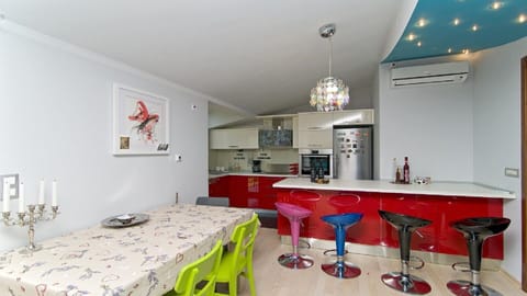 fully equippedred kitchen with large bar and dining table