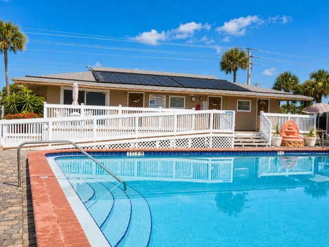 Outdoor pool with lounge chairs and patio tables for poolside festivities 