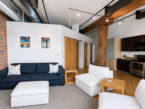Living room features a queen trundle style sleeper sofa and two oversized cozy seating chairs