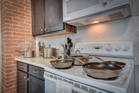 Electric range in kitchen with full set of pots and pans