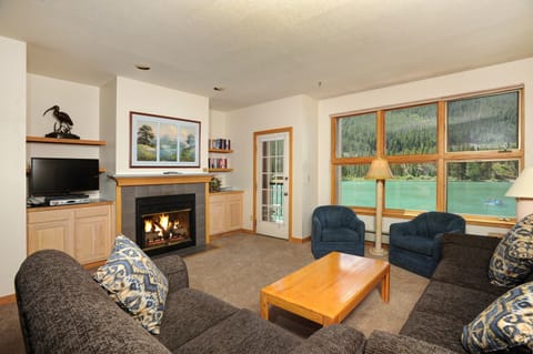 Relax in the cozy living area, complete with fireplace and TV. Views vary.