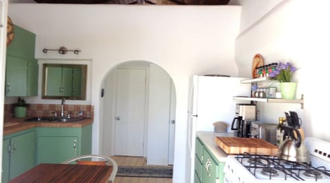 Kitchen view from french doors, bathroom door behind archway in background