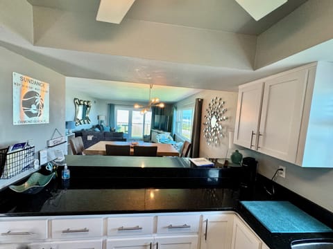 Kitchen looks out into the living space with granite countertops & fully stocked