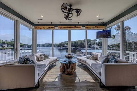 Stunning lakeside view from a cozy, modern living room with ample natural light.