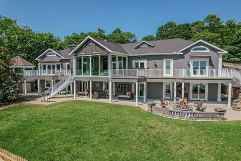Expansive lakefront home with large decks, a fire pit, and beautiful views.