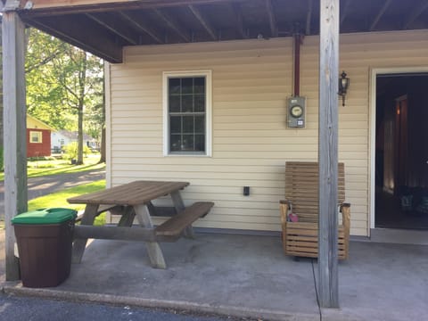 Back of house w picnic table, swing and chair 
