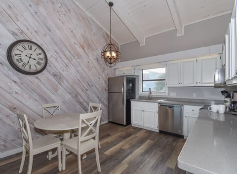 Kitchen dining area with small round table and four wood chairs