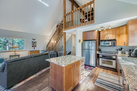 Great room with kitchen and stairs leading to open loft bedroom and lower level