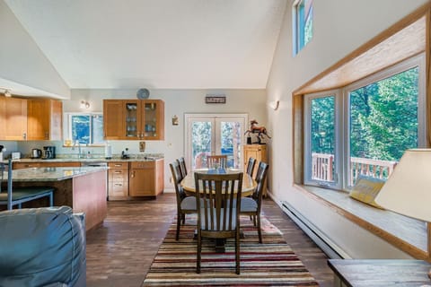 Large dining room table with french doors leading out to wrap around deck