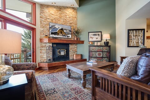 Sink into plush leather seating by your crackling fireplace, where rustic charm meets mountain elegance in this inviting living space.