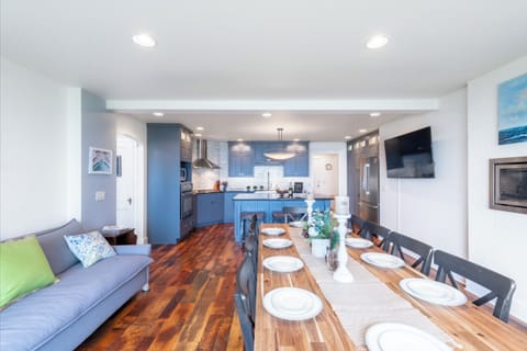 Combined kitchen and dining areas with old barn flooring, cozy fireplace and tv