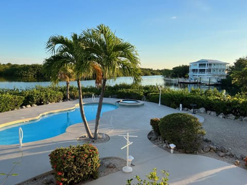 Backyard, pool & hot tub. Table w/ chairs as well as several lounge chairs. 