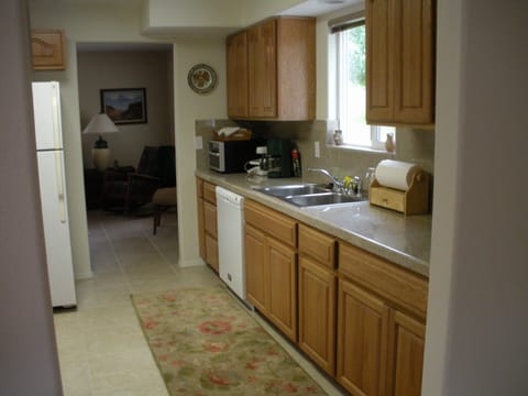 Kitchen with granite countertops looking into the living room.