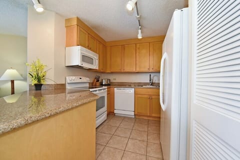 Functional kitchen with white appliance and wooden cabinets
