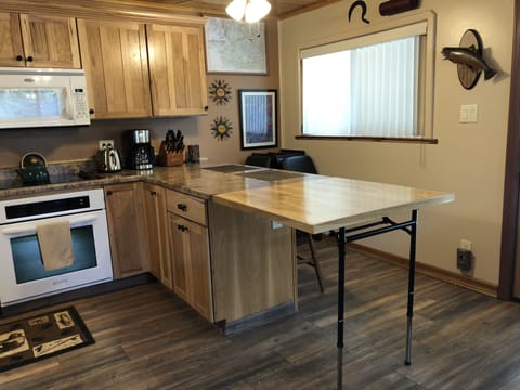 Folding extension for bar giving more room to eat in our cozy cabin. Folding chairs provided in corner. 