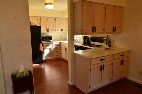 Kitchen equipped with a fridge, microwave, gas oven, Keurig and dishwasher.