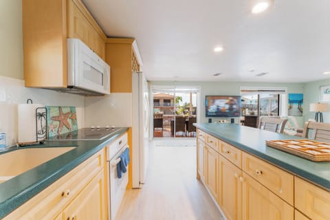 Canal-view kitchen with full appliances and island bar.