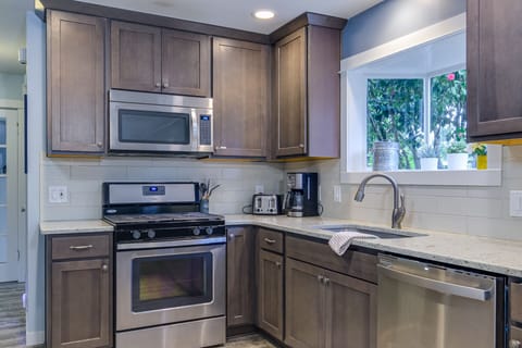 Kitchen with oven and gas cooking. Toaster & Coffee pot.