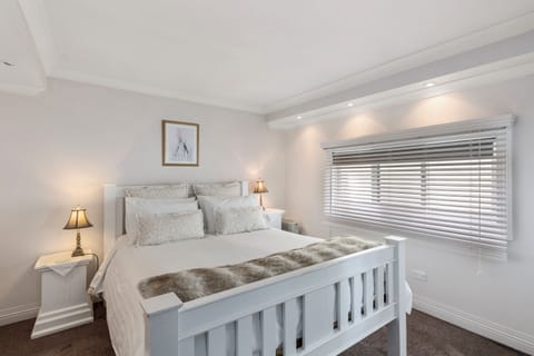 Ellie's Spa Cottage bedroom, beautiful bedding and soft lighting.