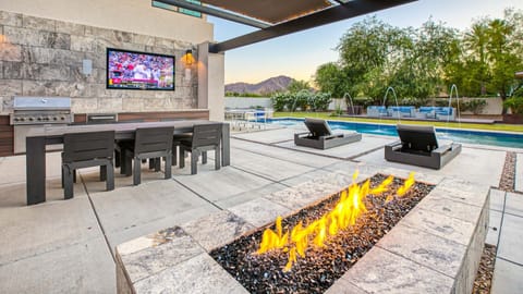 Beautiful, covered patio w/ firepit, outdoor kitchen, dining, & TV