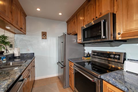 The kitchen features granite counters and stainless appliances.