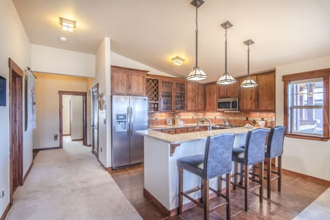 Kitchen - Granite counters, stainless steel appliances, and seating at the island.