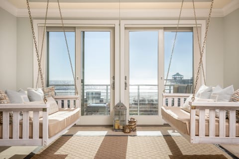 spacious living room with swings overlooking private balcony with beachfront views