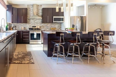 Large tile flooring extends across the kitchen.