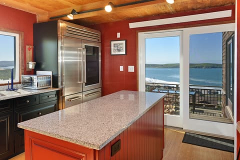 Kitchen leads out to a deck with a table and the grill.