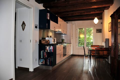 Living-room with furniture, kitchen and window on the garden and canal.