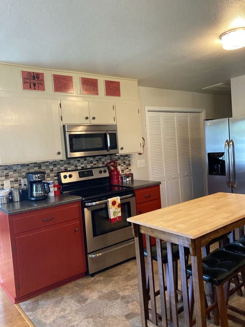 Kitchen area showing range, microwave, refrigerator and seating for four