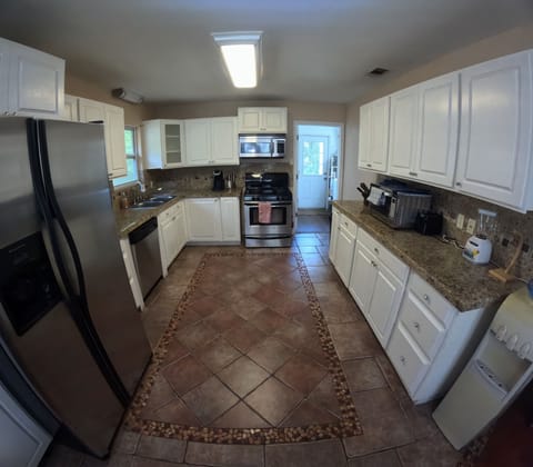 Large open area fully stocked kitchen with lots of counter space.