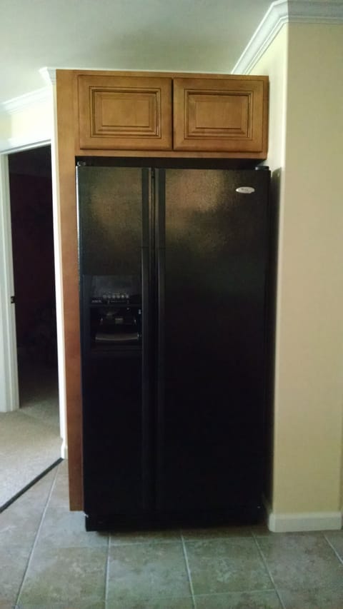 Additional storage above full size side by side frig. Ice/water in door.