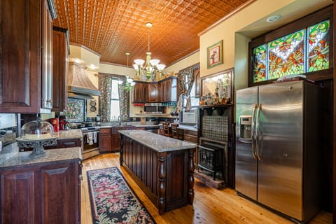 The gorgeous Entertainer's kitchen with original tin ceiling and fireplace.