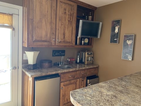Wet bar with mini fridge and ice maker water view