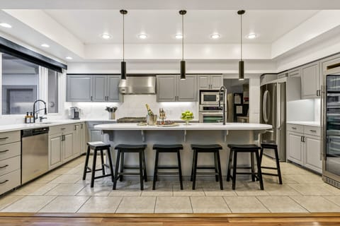A chef's kitchen with 2 sinks, 2 dishwaters, and professional stove fully loaded